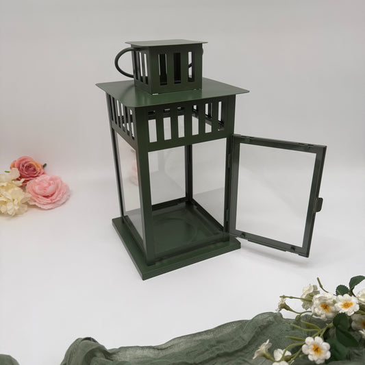 Green metal lantern with open door on a white background with flowers.