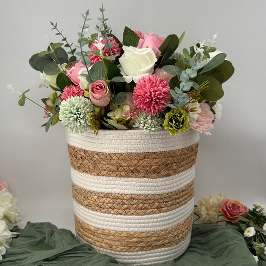 Decorative woven basket with flowers on a neutral background
