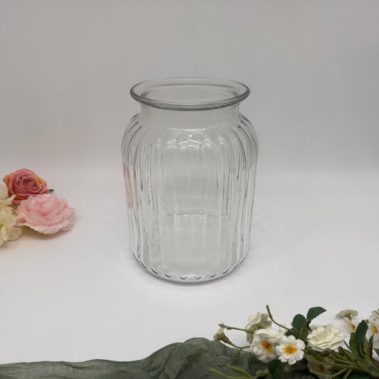 Clear glass jar with floral decorations on a white background.