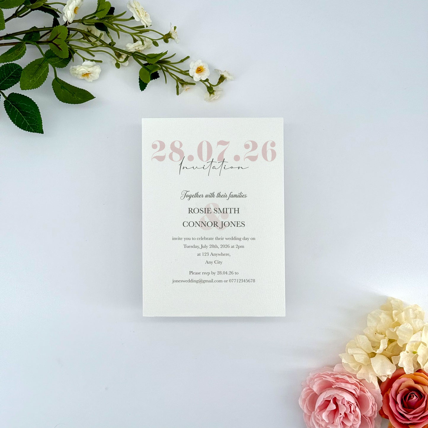 Wedding invitation card with floral decorations on a light background