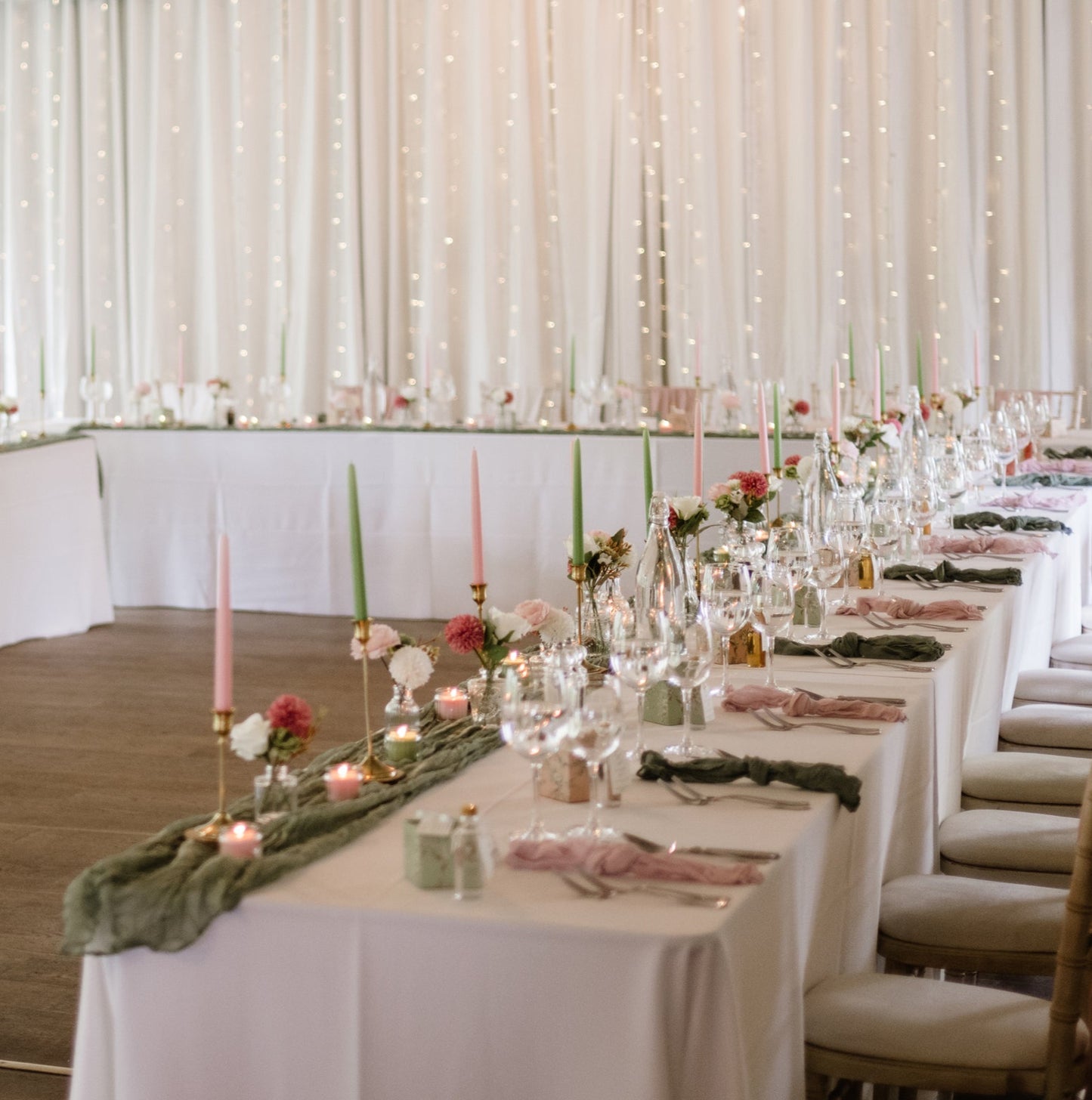 Wedding reception setup with tables, chairs, and decorations in a large room.