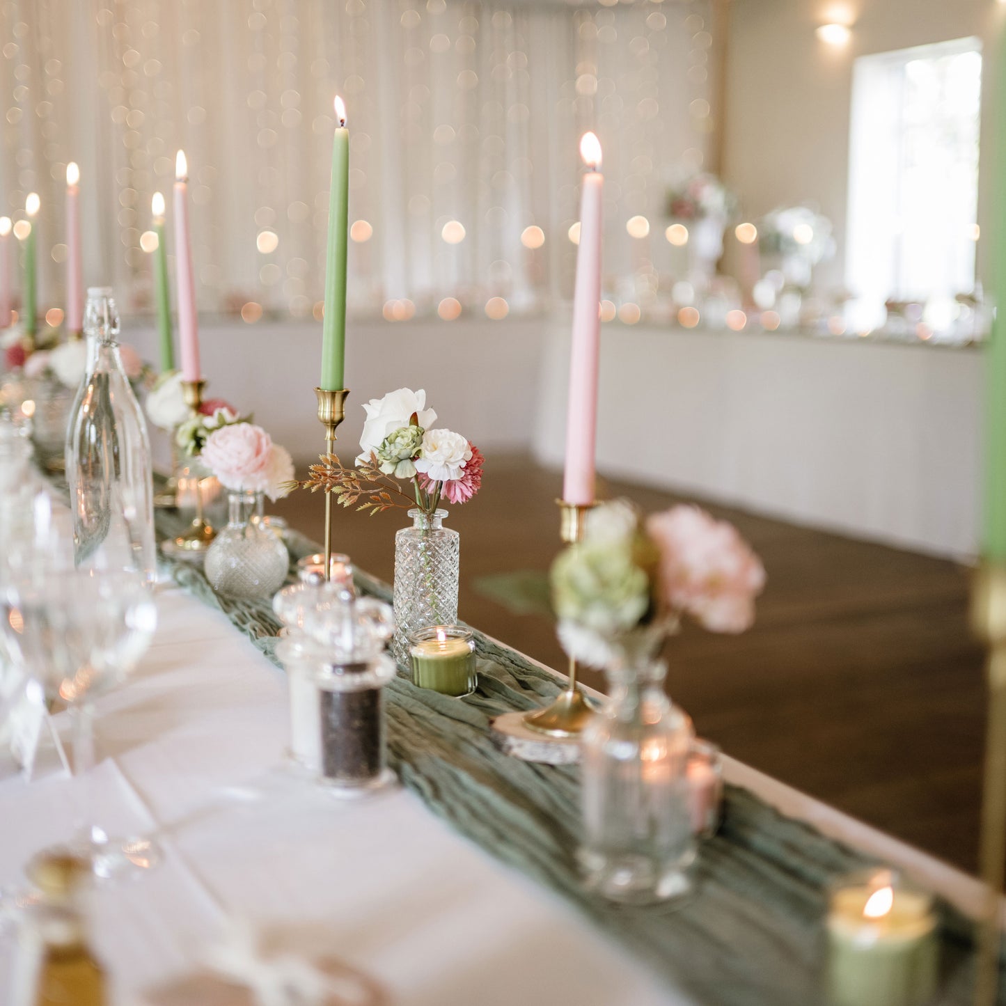 Decorative table setting with candles and flowers in a softly blurred room.