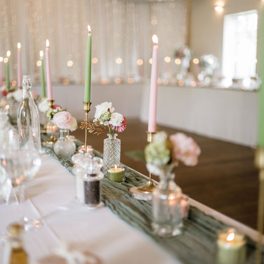 Decorative table setting with candles and flowers in a softly blurred room.