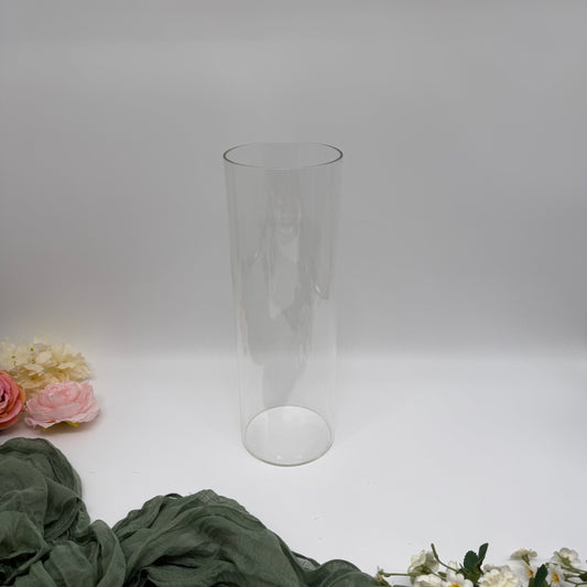 Empty Hurricane Vase sitting on a white background with flowers placed to the left-hand side
