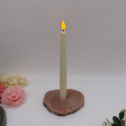 Candle on a wooden coaster with flowers on a white background
